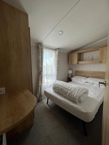a small bedroom with a bed and a window at Sunnycott Caravan Park in Cowes