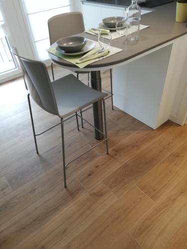 a table and chairs in a kitchen with wooden floors at Casa Fullin in Belluno