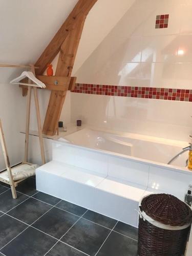 a bathroom with a white bath tub in a attic at Villa MY le Mans in Saint-Saturnin