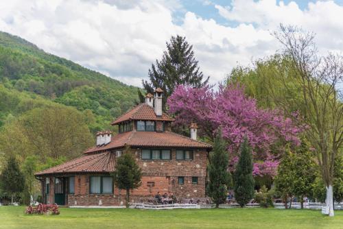 Un gran edificio de ladrillo con una torre en la parte superior. en B&B Etno Village Sunčana Reka, en Banja Koviljača