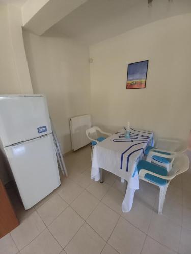 cocina con mesa, sillas y nevera en A Relaxing and Peace home for the best Vacation, en Artemida