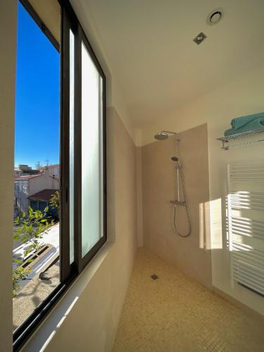 La salle de bains est pourvue d'une douche et d'une fenêtre. dans l'établissement Maï Homes - La Villa Bompard, à Marseille
