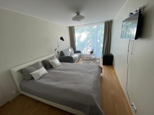 1 dormitorio con 1 cama, TV y silla en Lovely Aisa studio in Pärnu en Pärnu