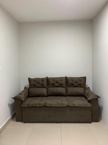 um sofá castanho num quarto com uma parede branca em PALLADIUM APART SERVICE em São Vicente
