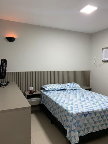 a bedroom with a bed with a blue comforter at PALLADIUM APART SERVICE in São Vicente