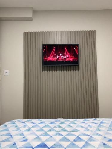 TV en la pared de una habitación en PALLADIUM APART SERVICE, en São Vicente