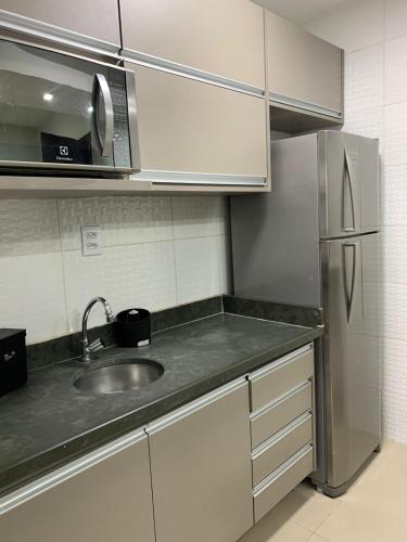 uma cozinha com um lavatório e um frigorífico em PALLADIUM APART SERVICE em São Vicente