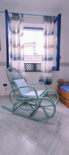 einen Schaukelstuhl in einem Zimmer mit Fenster in der Unterkunft Casa Raja in Gaeta