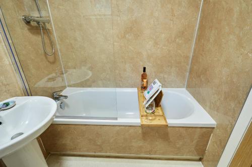 y baño con ducha, lavabo y bañera. en Etive, Beautiful Lochside Apartment with balcony, en Fort William