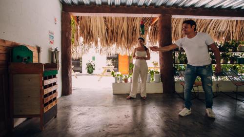 a man and a woman standing in a room at Makenke Hostel By Los Colores Ecoparque in Doradal