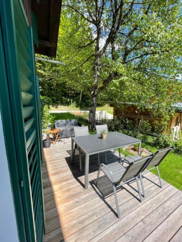 a patio with a table and chairs on a deck at s´Manz in Grundlsee