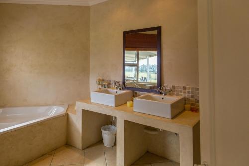bagno con 2 lavandini, vasca e specchio di Quinta Da Montanha a Rheenendal