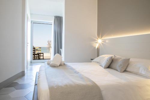 a bedroom with a large bed with a view of the ocean at Hotel Villa Ambra in Orbetello