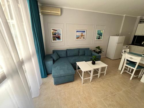 a living room with a blue couch and a table at TM Panorama Beach Apartments in Nesebar