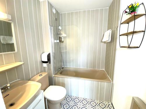 La salle de bains est pourvue d'une baignoire, de toilettes et d'un lavabo. dans l'établissement Le Balcon des Ecrins, à Réallon