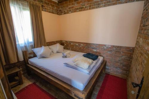 a bed in a room with a brick wall at Etno Selo Svodje in Vlasotince