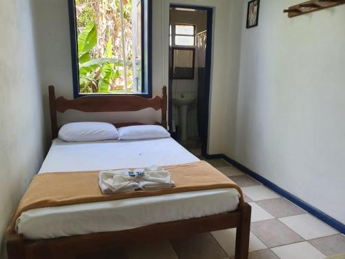 a bedroom with a bed with a towel on it at Pousada Estrada Real in Milho Verde