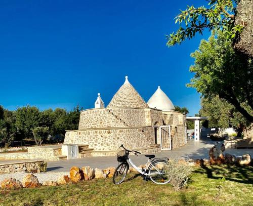 a bike parked in the grass in front of a building at I trulli di Uma in Carovigno