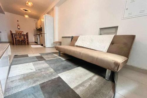 a couch in a living room with a kitchen at Casa de Santa Maria 113 in Castelo Branco