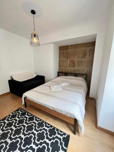 a bedroom with a bed and a black and white rug at Casa de Santa Maria 113 in Castelo Branco