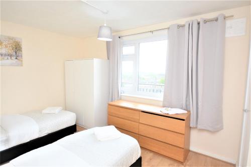 a small bedroom with a dresser and a window at Beautiful Two Bedroom Flat in Brixton London in London