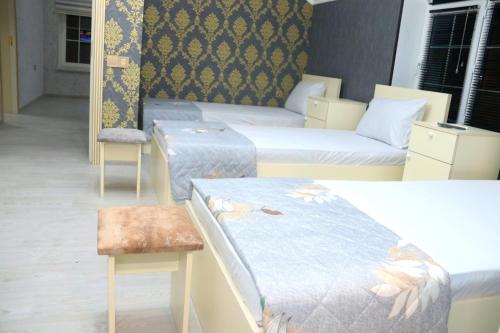 a hotel room with two beds and a chair at Golden House in Gabala