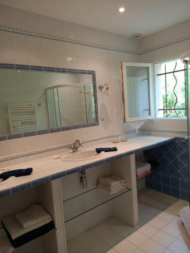 une salle de bain avec un lavabo et un miroir dans l'établissement Sympathique Maison au Soleil & Whirlpool Privé dans Quartier Calme !, à Entrecasteaux