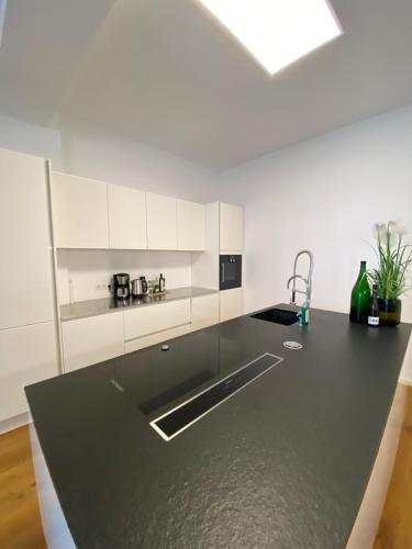 uma cozinha com armários brancos e um balcão preto em Loft in bester Lage em Landau in der Pfalz