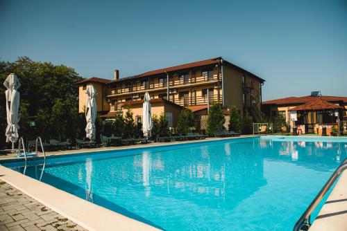 a large swimming pool in front of a hotel at Hanul Lui Bogdan Economy INN in Făget