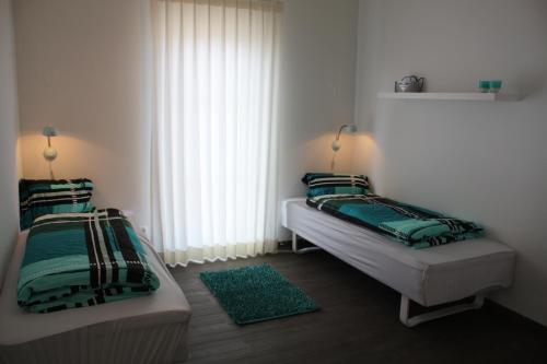 1 dormitorio con 2 camas y ventana en Ferienhaus Heimathafen, en Sierksdorf
