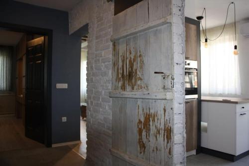 an old wooden door in a kitchen with a brick wall at Exclusive-Luxury Mihajlovic Apartment-STRICT&CENTRE in Skopje