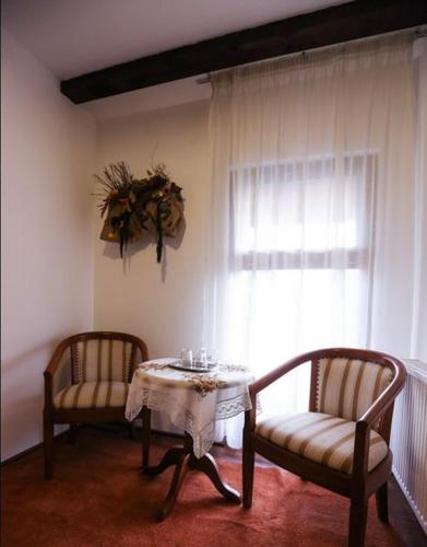 a room with two chairs and a table and a window at Pensiunea Roua Muntelui in Brăzeşti
