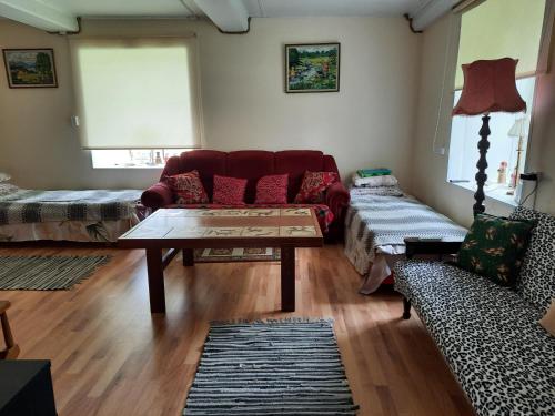 uma sala de estar com um sofá vermelho e uma mesa de centro em Ojavere Puhkemaja em Plika