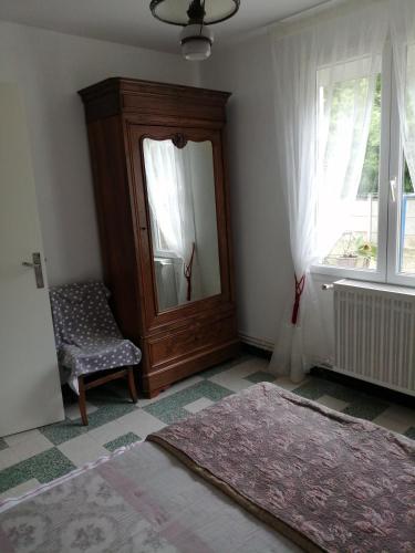 Cette chambre comprend un miroir, une chaise et une fenêtre. dans l'établissement Villa l'bontemps, à Saint-Georges-de-Didonne
