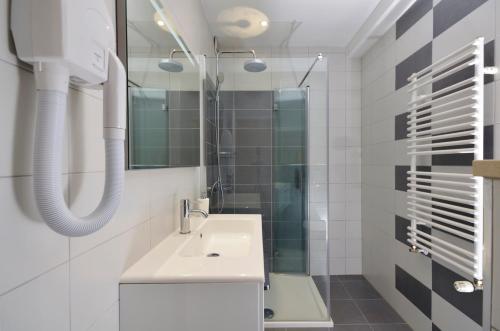 Baño blanco con lavabo y espejo en Villa Dalmatia Apartments, en Brela