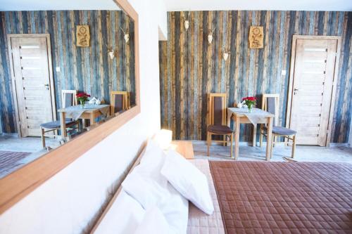 a bedroom with two tables and chairs and a mirror at Willa Mysliwska in Krynica Morska