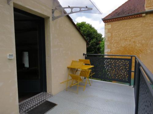 a patio with a table and chairs on a balcony at Le Studio des Gîtes Aérostier in La Roque-Gageac