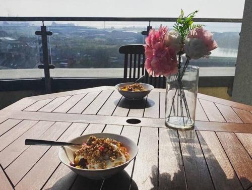 a wooden table with a bowl of food and flowers on it at 3 Bedroom Penthouse Apartment in larne in Larne