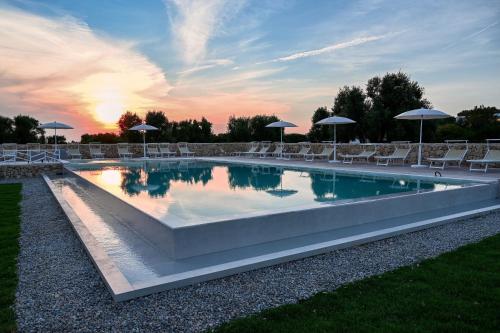 a large swimming pool with chairs and umbrellas at Macchia Piccinna in Maruggio