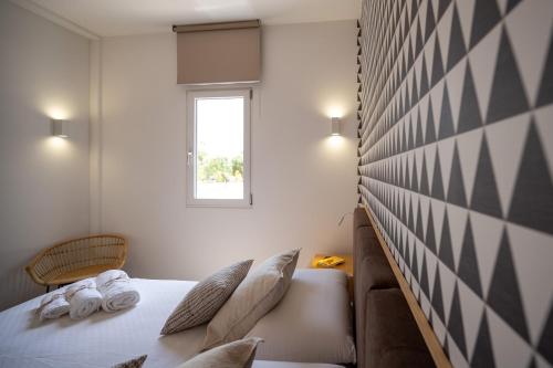 a bedroom with a bed and a window at Macchia Piccinna in Maruggio