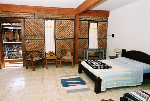 1 dormitorio con 1 cama, mesa y sillas en Quari Quara BY MN Hotéis, en Rio das Ostras