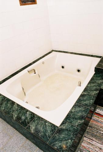 a white bath tub sitting in a bathroom at Quari Quara BY MN Hotéis in Rio das Ostras