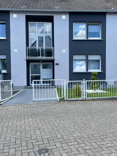 ein Haus mit einem weißen Zaun davor in der Unterkunft Monteurzimmer für 2 Person - Nähe DO-Flughafen in Dortmund