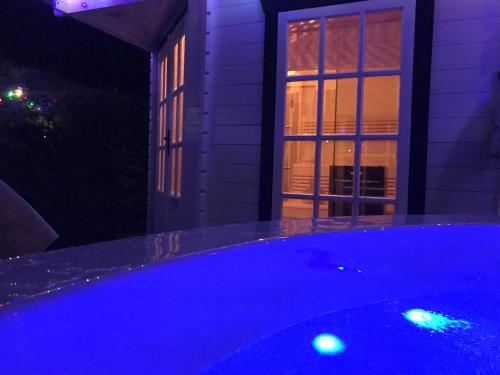 a swimming pool with blue lights in front of a house at Studio ter Duyn in Ouddorp