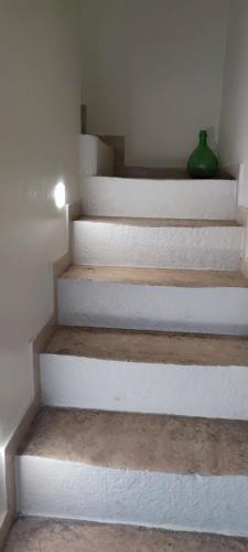 a white staircase with a green vase on it at Lithos house pt 1p e 2p in Monopoli