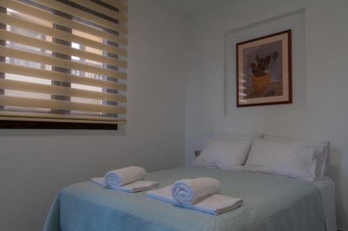 a bedroom with a bed with two towels on it at Chelidoni apartment ground floor in Heraklio
