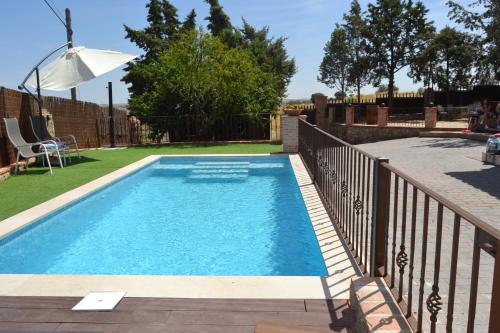 a swimming pool in a yard with a fence at Casa Rural La Finca in Guadamur