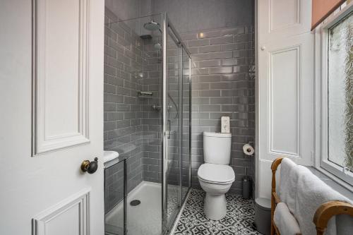a bathroom with a toilet and a glass shower at Annfield House, Callander in Callander