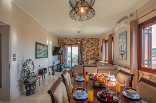 a dining room with a table and a living room at Villa Stathatos in Fiskardho
