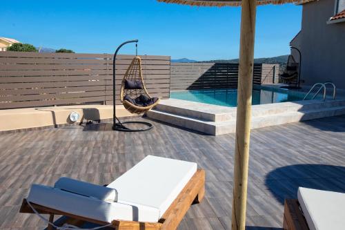 a patio with a hammock and a swimming pool at Villa Stathatos in Fiskardho